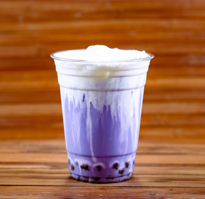 This unique drink is a Ube Milk Tea and it comes with Boba and is topped with Tiramisu Foam.