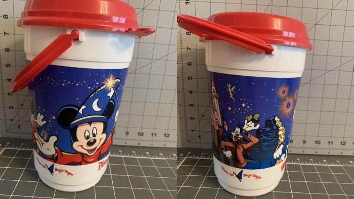 This Disneyland popcorn bucket shows Sorcerer Mickey Mouse, Minnie Mouse, Donald Duck, Goofy, and Tinker Bell.